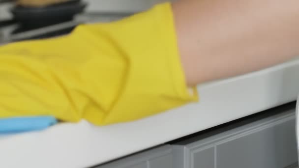 Femme au foyer en gants jaunes laver la table avec chiffon bleu et détergent . — Video