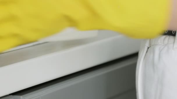 Mujer con guantes amarillos lavar la mesa con trapo amarillo y detergente . — Vídeos de Stock