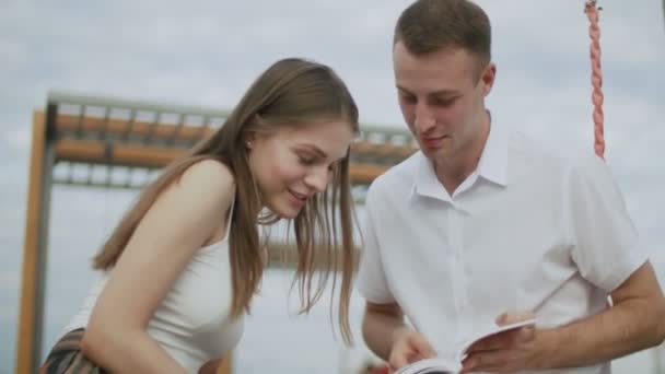 Ein paar Studenten lesen im Park Bücher. Zeitlupe — Stockvideo