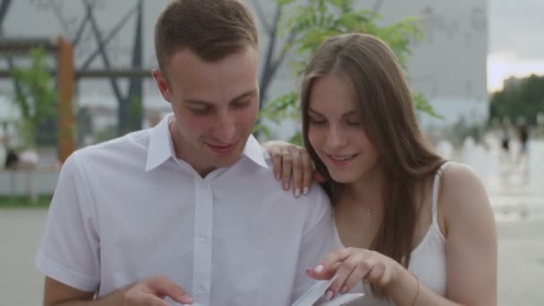 Portret van koppel studenten lezen boek in park — Stockvideo