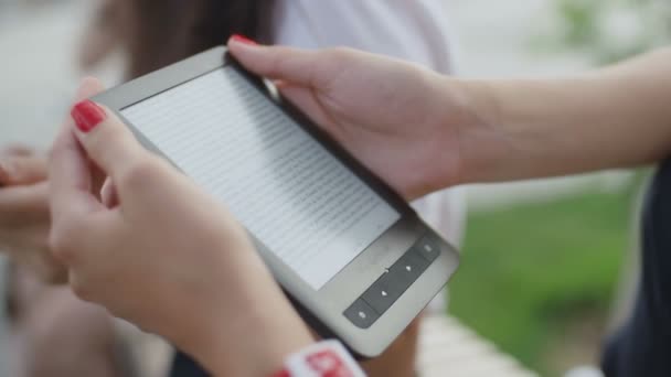 Mãos das mulheres com ebook no parque — Vídeo de Stock