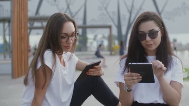 Deux belles femmes lisent un livre à l'extérieur — Video