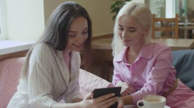 Kafedeki kızlar komik bir kitap okuyor..