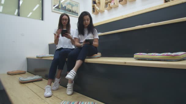 二人の友人は現代の教室で本を読んでいる — ストック動画