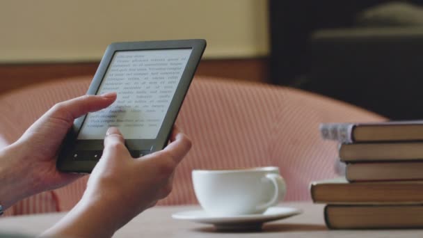 Chica leyendo un libro electrónico en la cafetería — Vídeos de Stock