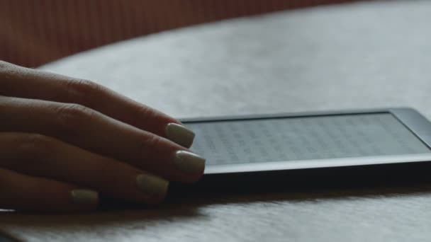 Крупним планом молода жінка читає електронну книгу — стокове відео