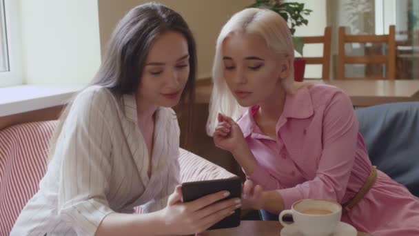 Dva studenti čtou ebook v kavárně — Stock video