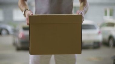 Postacı paketi kameraya verir.