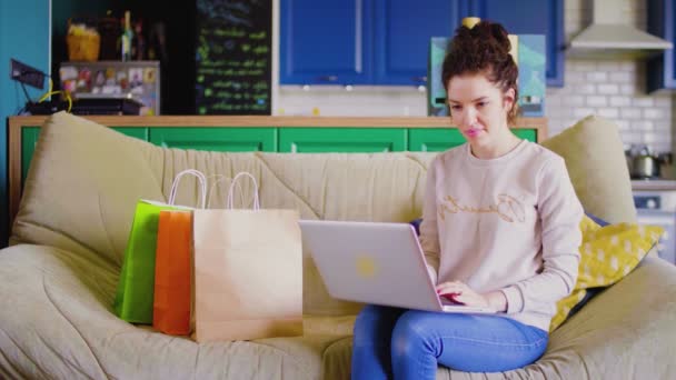 Mujer está sentada en el sofá y charlando en Internet. Mujer mujer haciendo compras en línea . — Vídeos de Stock