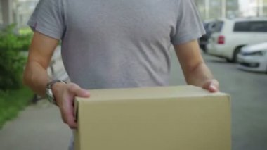 Postacı paketi kameraya verir.