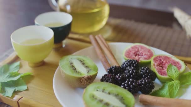 Teapot with green tea with fruits — Stock Video