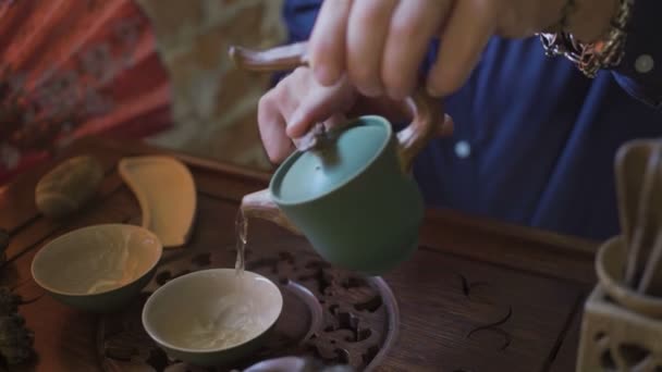 在中国传统茶会上，男子将绿茶由茶壶倒入盖旺. — 图库视频影像