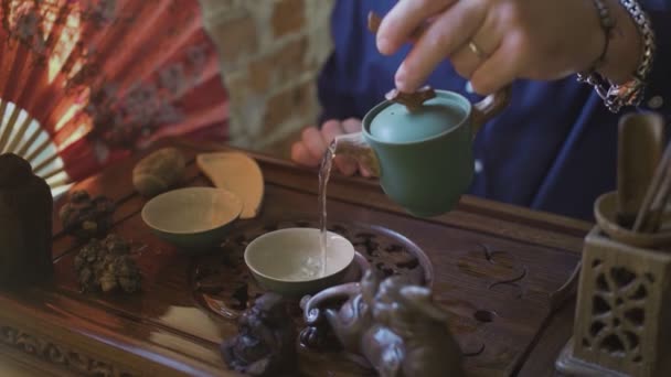 Slide Shot of Man Nalanie zielonej herbaty z czajnika do Gaiwan na tradycyjnej chińskiej ceremonii herbaty. — Wideo stockowe
