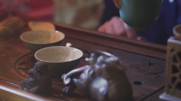 男子将绿茶由茶壶倒到盖旺的特写 — 图库视频影像