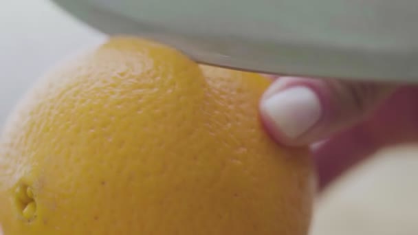 Corte de fruta naranja para exprimir jugo fresco. Cerca de las manos femeninas — Vídeo de stock