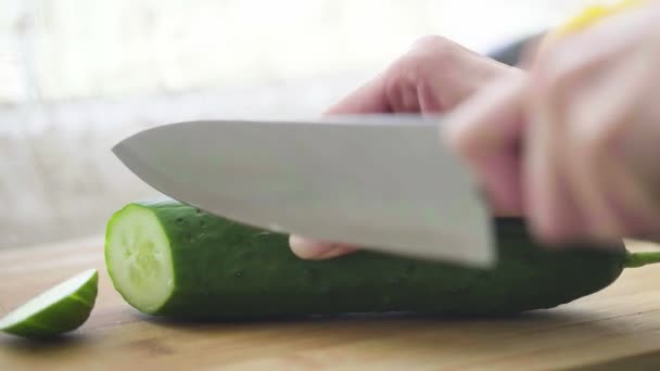 Жінка ріже огірок на кухні — стокове відео