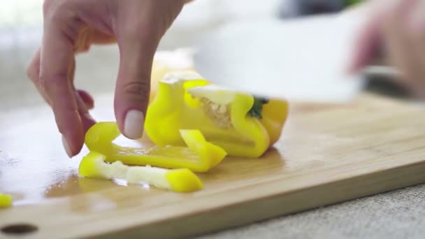 Шматочки різання шеф-кухаря жовтого перцю крупним планом повільний рух — стокове відео