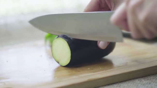 Manos de mujer cortando berenjena sobre tabla de madera — Vídeos de Stock