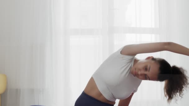 Primo piano di giovane donna afro-americana sportiva che pratica stretching a casa — Video Stock