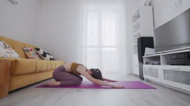 Genç ve güzel bir kadın yoga pozları veriyor, High Cobra ve Genişletilmiş Childs.