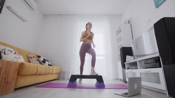 Young beautiful woman stepping on a step platform and lift up legs — Stock Video