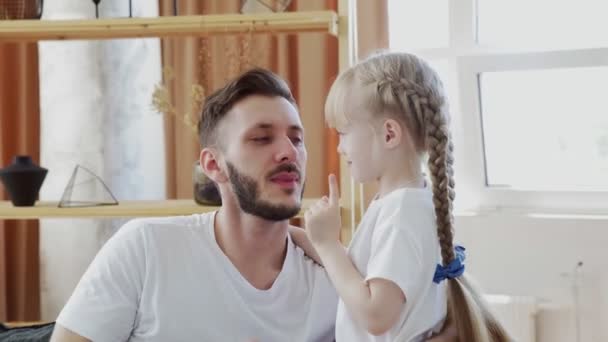 Närbild av far och dotter i vita t-shirts rör vid deras näsor. Faderns dag koncept — Stockvideo