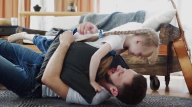 Mutlu baba, küçük kızıyla vakit geçiriyor. Yere yatar ve sarılırlar.