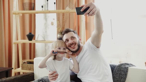 Junger Vater und seine Tochter machen Selfie zu Hause — Stockvideo