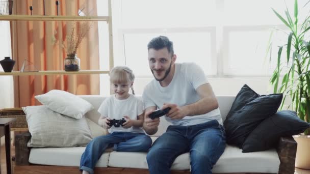 Baba ve kız oyuncular evde video oyunu oynuyorlar. — Stok video