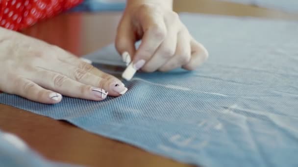 Nahaufnahme der Hände einer Schneiderin, die in ihrem Geschäft arbeitet, Zeichnung einer Vorlage auf Stoff — Stockvideo