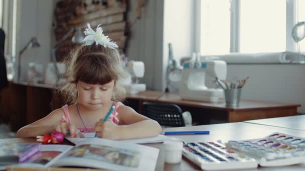 Pequena menina bonita em desenha com marcadores coloridos na mesa no quarto — Vídeo de Stock