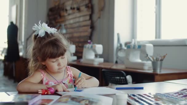 Slide tiro de menina em sorteios com marcadores coloridos na mesa no quarto — Vídeo de Stock