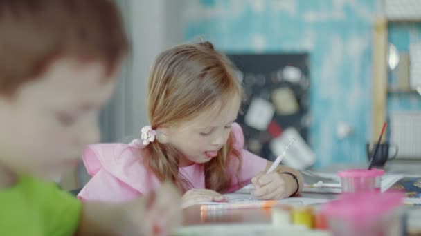 Kleines Mädchen müht sich sehr, zu zeichnen. Kindergartengruppe — Stockvideo