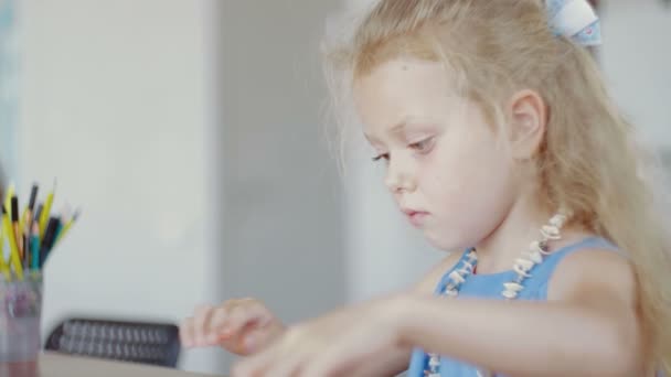 Симпатична маленька дівчинка в синій сукні з пластиліну в дитячому саду . — стокове відео