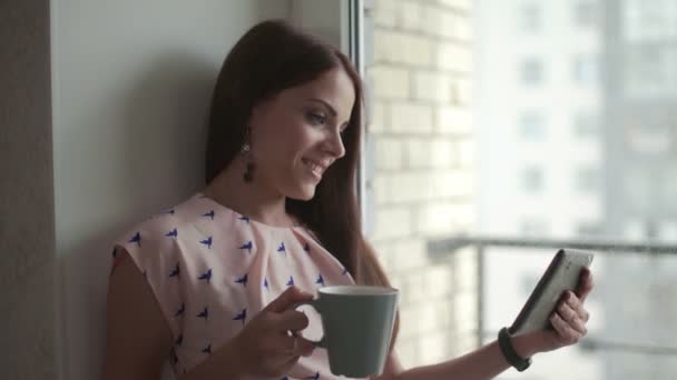 Kobieta ogląda film na tablecie i pije kawę — Wideo stockowe