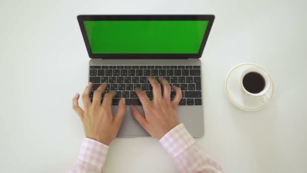 Vrouw werkt aan haar laptop met groen scherm, bovenaanzicht — Stockvideo