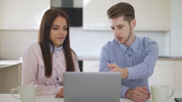 Paar zijn met behulp van notebook om online te winkelen in de keuken — Stockvideo