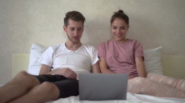 Çift komik film izlemek için bilgisayar kullanıyor.