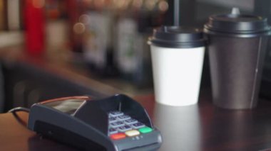 Kafede beyaz ceketli bir iş kadını bunun bedelini akıllı bir saat ve terminal kullanarak ödüyor.