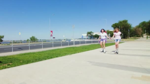 Jovens meninas bonitas patinando em um parque . — Vídeo de Stock