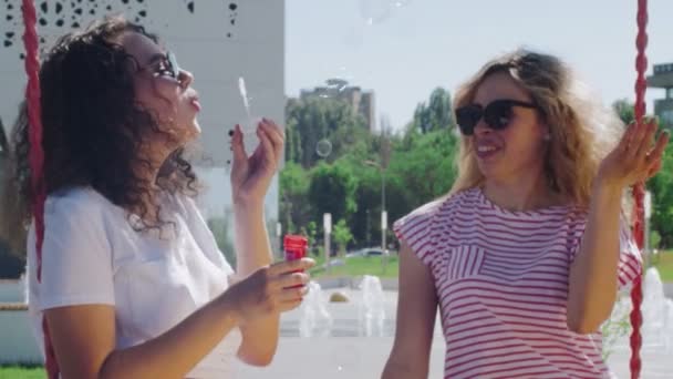 Dívky foukání bubliny v parku — Stock video