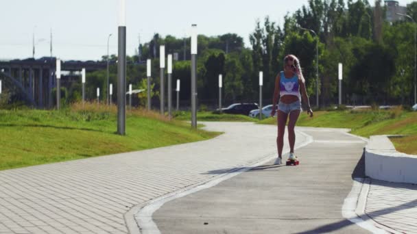 Dívka v krátkých kraťasech na skateboardu — Stock video