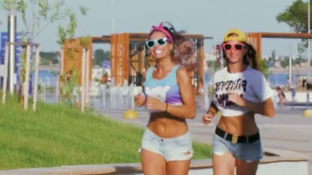 Deux femmes sexy en lunettes de soleil courent dans le parc — Video