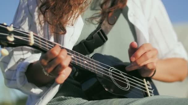 Xlose up van vrouw spelen ukelele gitaar ourdoors — Stockvideo