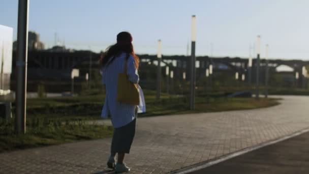 Hipster mujer caminando en el parque durante la puesta del sol — Vídeos de Stock