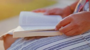 Kadın kitap sayfasını çeviriyor.