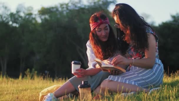 Две девушки обсуждают интересную книгу — стоковое видео