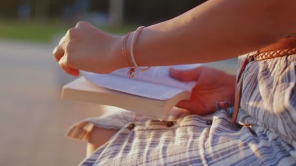 Close up de mulher está lendo livro no parque da cidade . — Vídeo de Stock