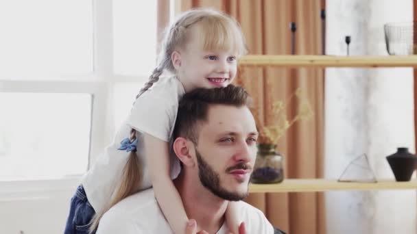 Glücklicher Familienvater mit süßer kleiner lustiger Tochter zu Hause. Vatertagskonzept — Stockvideo