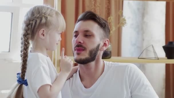 Großaufnahme von Vater und Tochter in weißen T-Shirts rührt an der Nase. Vatertagskonzept — Stockvideo